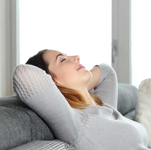 HCD Happy relaxed woman resting on a couch at home